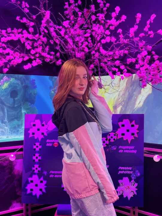 Steph embaixo de uma árvore de flores rosas numa ativação